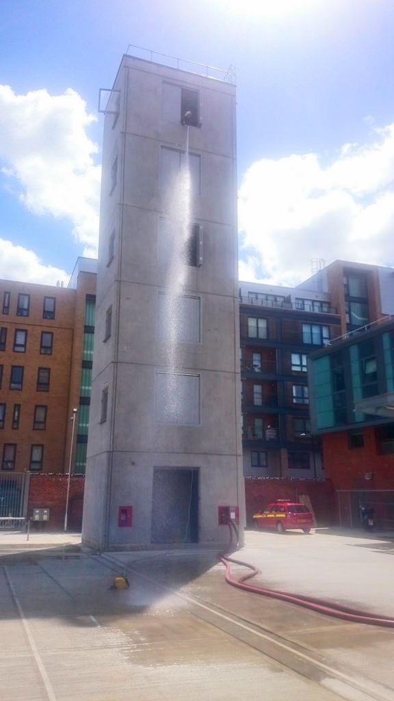 Freestanding precast stair cores with water being hosed out from the top flight