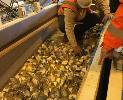 Milbank employee quality checks a flint embossed precast concrete retaining wall