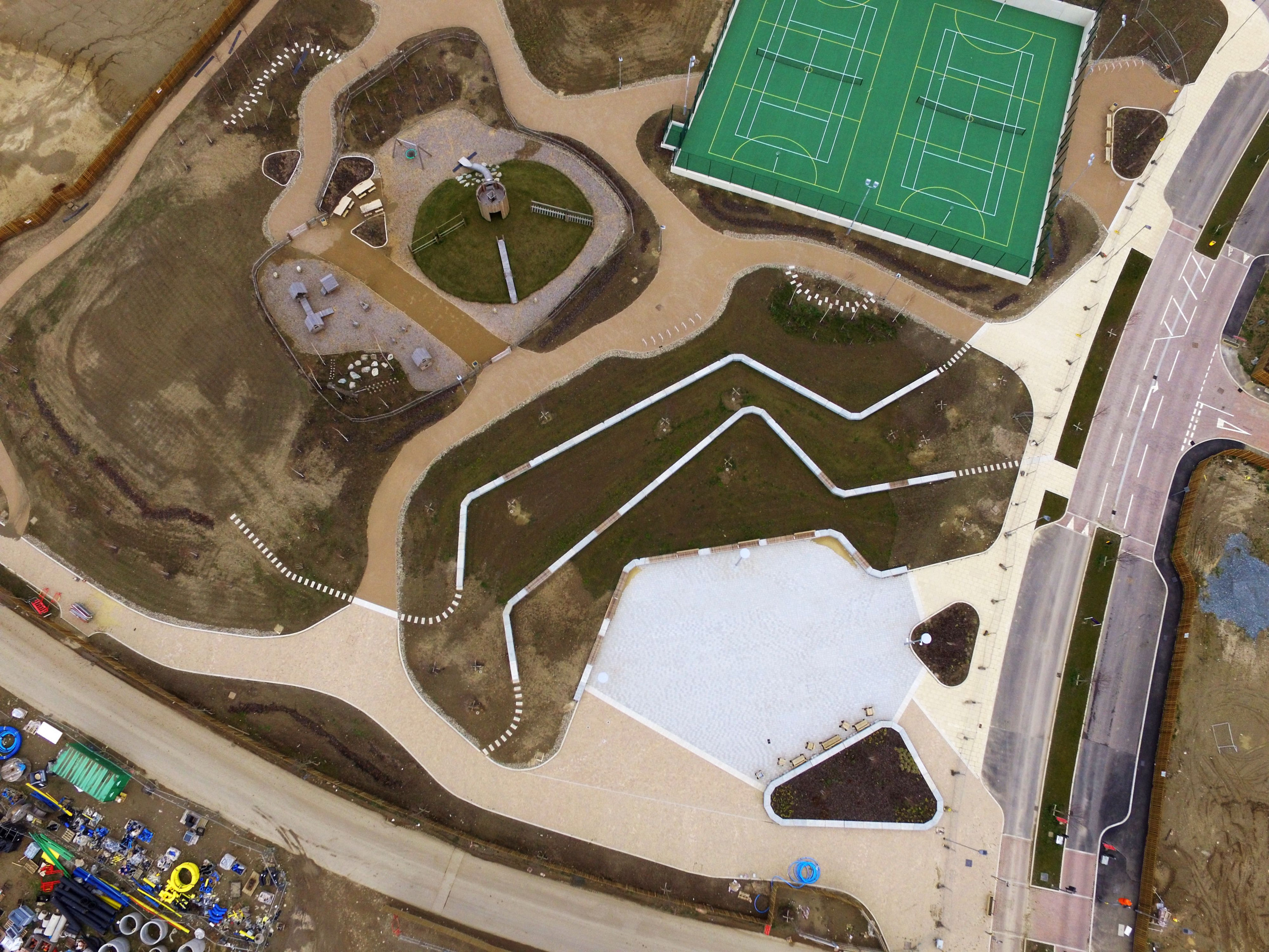 Aerial view of bespoke precast concrete seating units in housing development with tennis courts and play area