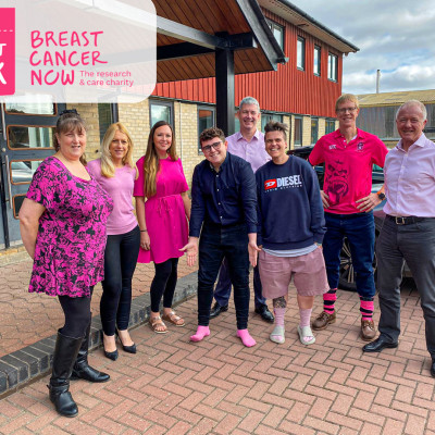 staff members wear pink items of clothing in support of breast cancer now