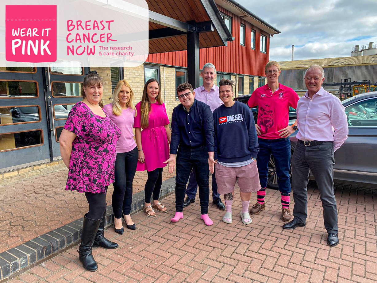 staff members wear pink items of clothing in support of breast cancer now