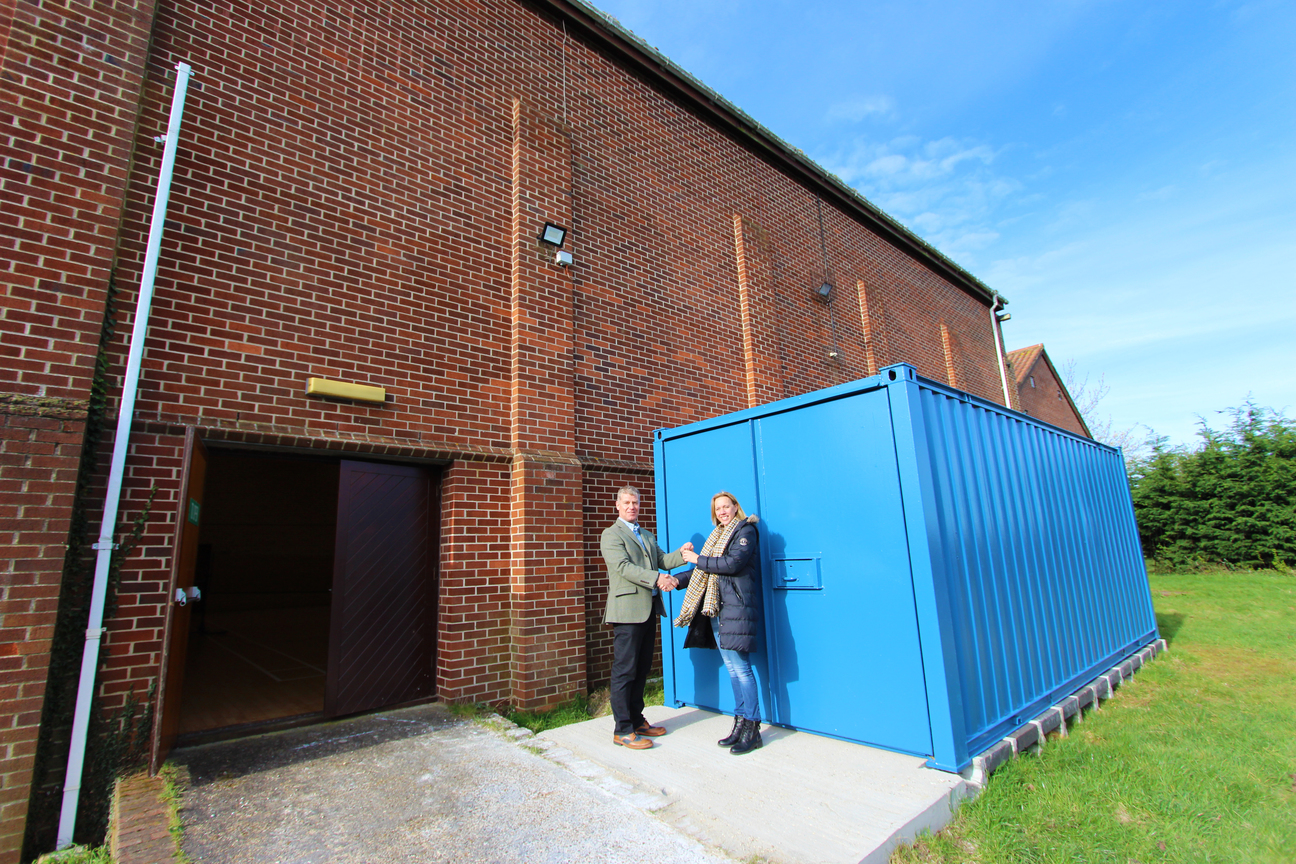 Operations Manager Philip Maxwell hands over donated container to Earls Colne Recreation Centre