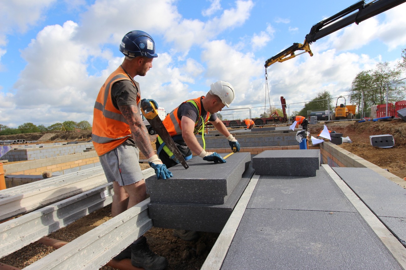 Milbank team cut EPS panels with saw for installation between concrete beams