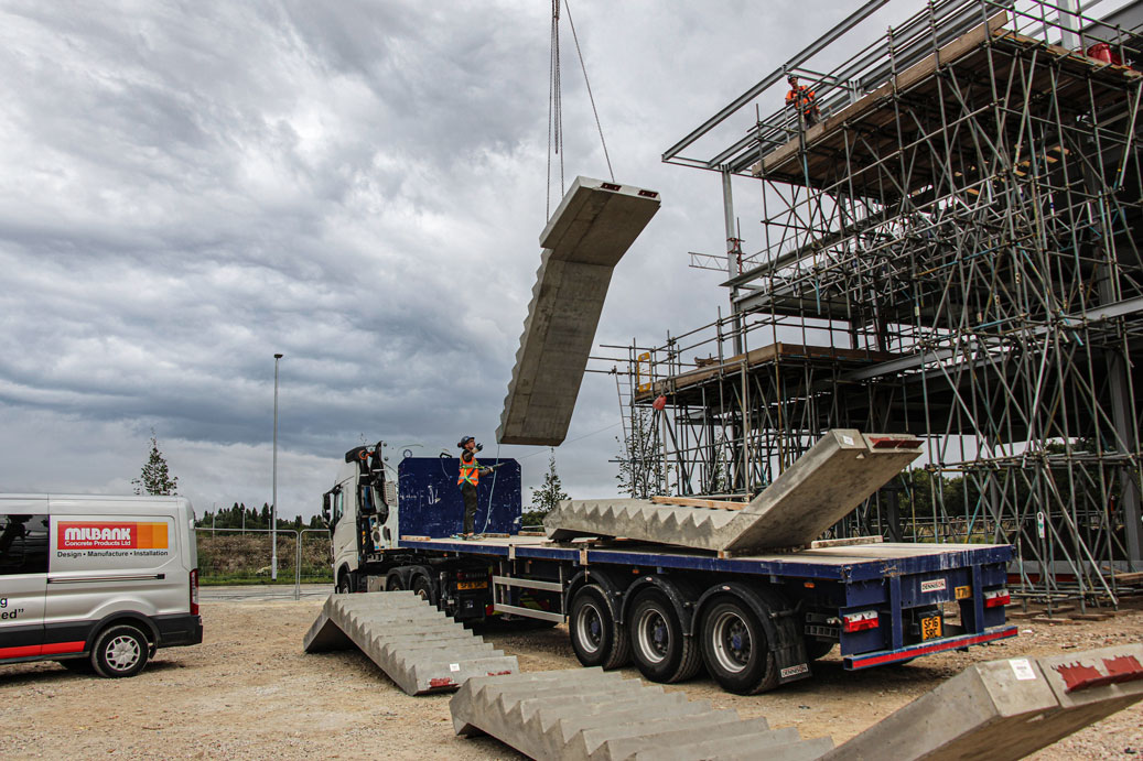 precast concrete stair is suspended by mobile crane during installation on site