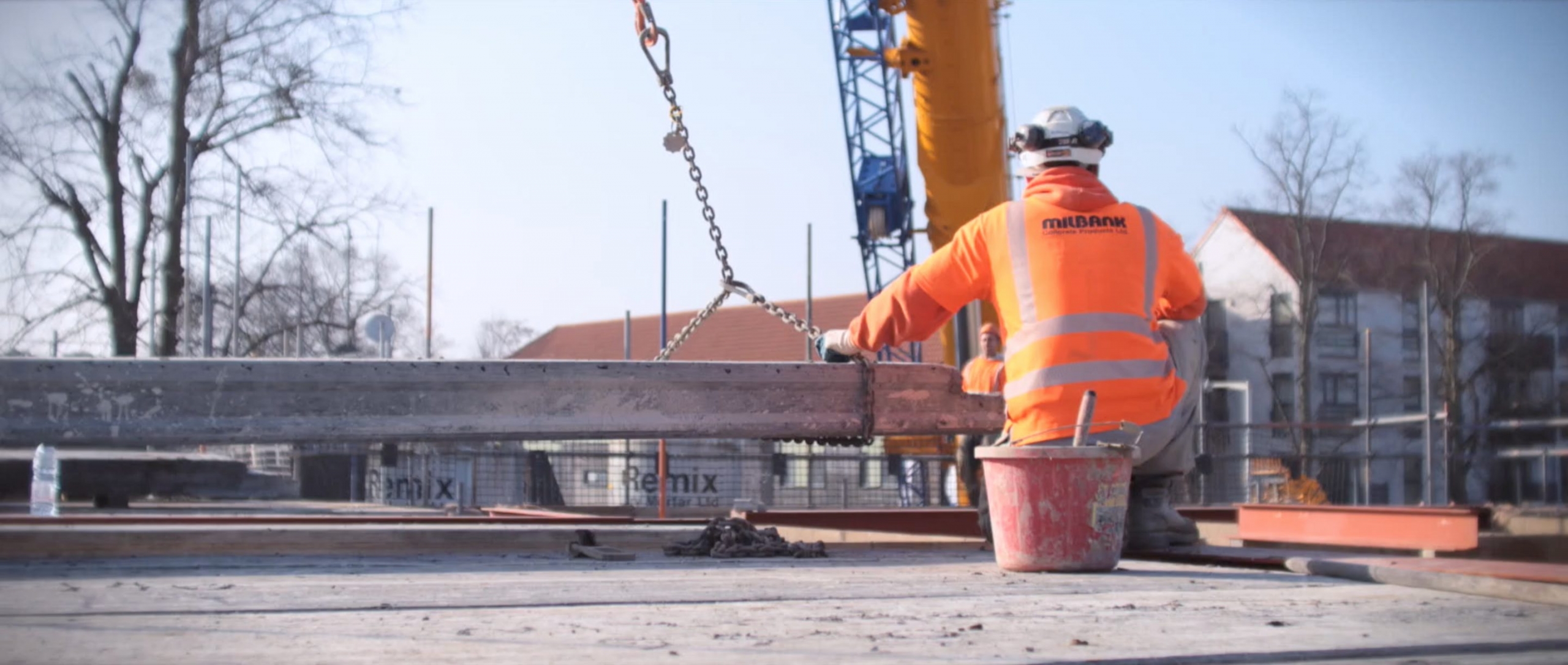 Milbank site employee crouches with hollowcore flooring plank