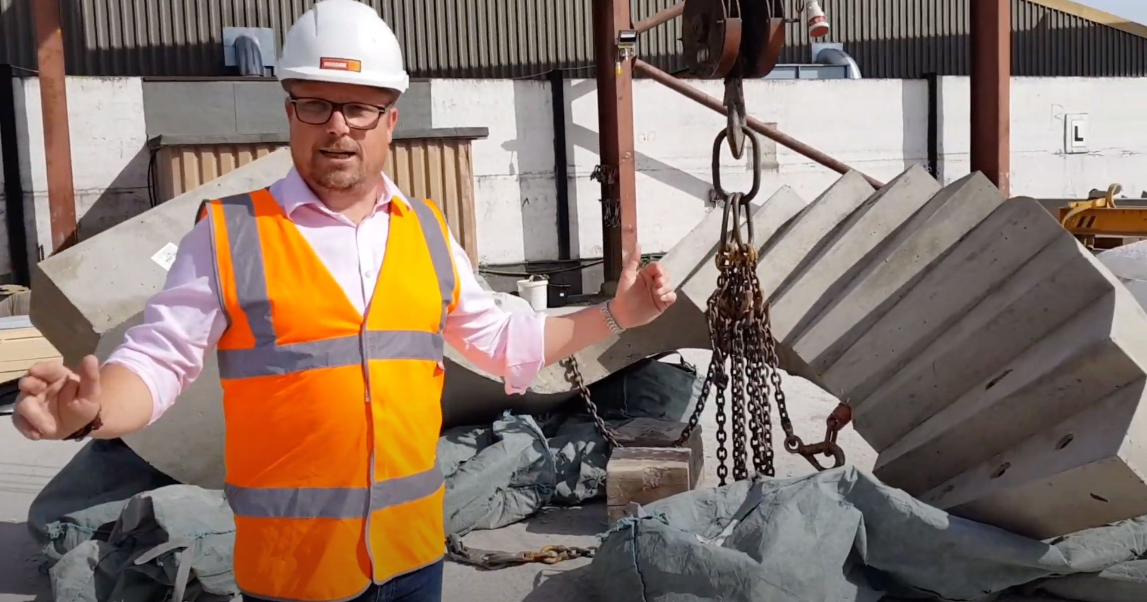 Mark Ellis poses with specialist precast concrete curved staircase in production yard