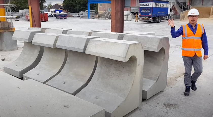 Mark Ellis poses with specialist precast concrete sea defence wave walls in production yard