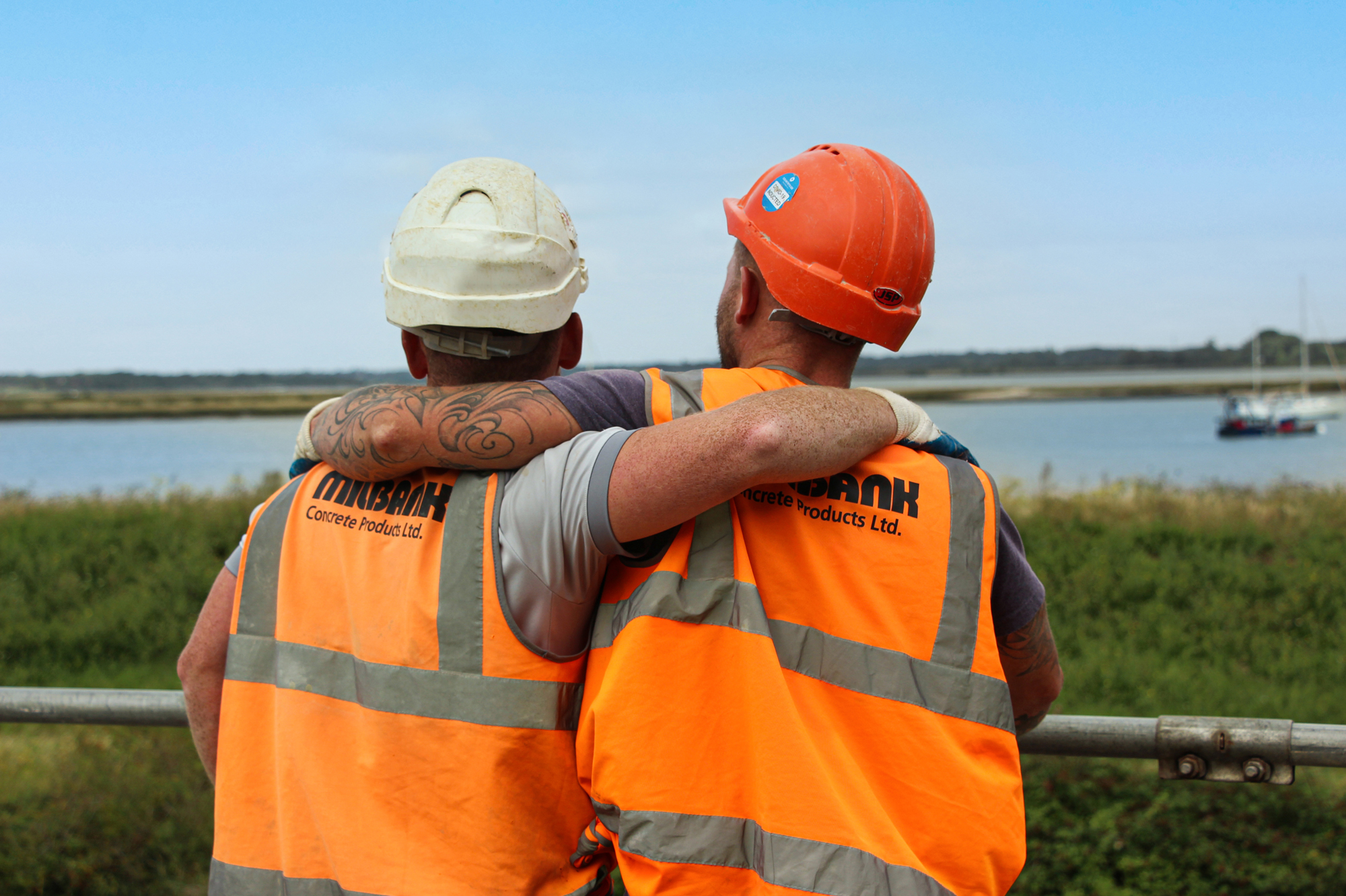 two Milbank employees stand side by side with their arms around each other