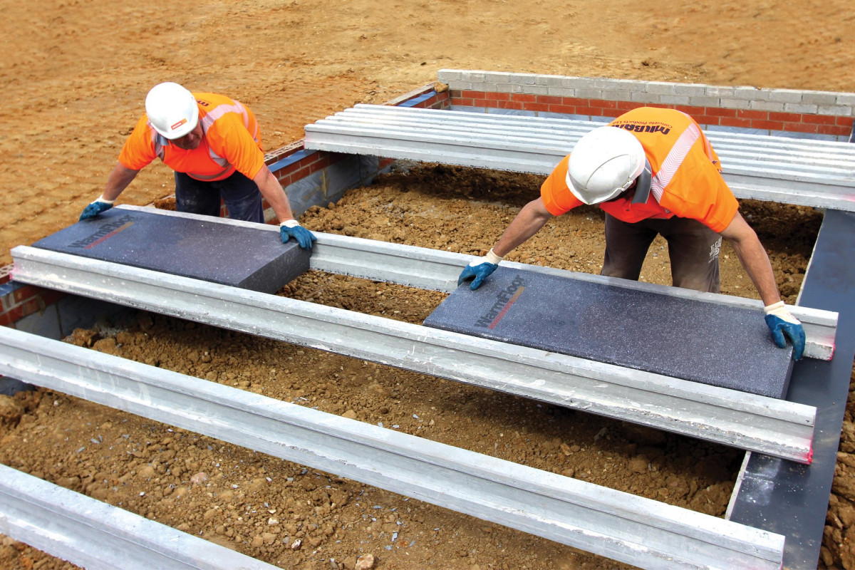 Two Milbank employees install WarmFloor Pro flooring on site