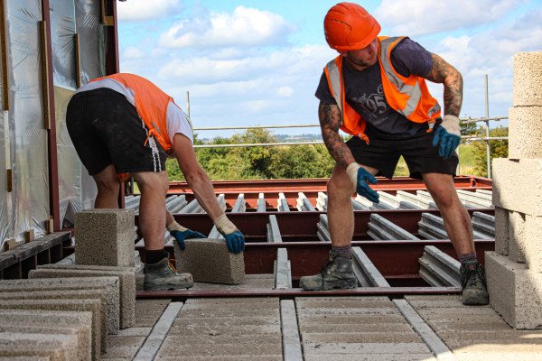 Milbank employees installing beam and block flooring on site