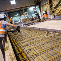 Factory employee prepares bespoke precast concrete mould with rebar