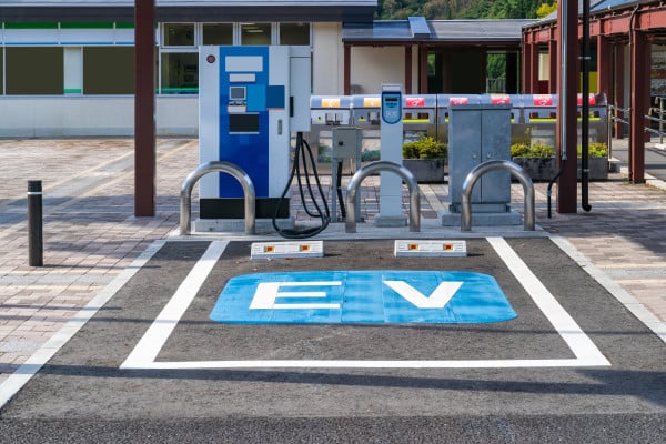 An EV charging bay in a car park is highlighted by a painted sign within the bay